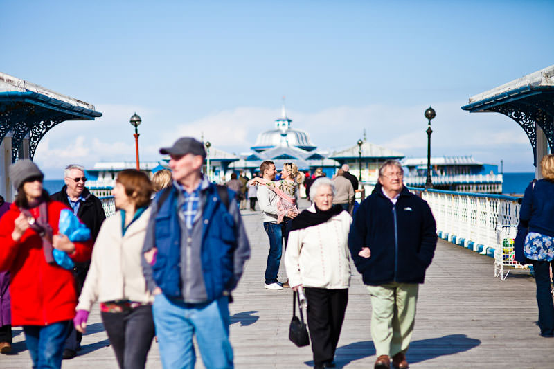 Llandudno pier engagement shoot, couple amongst crowd